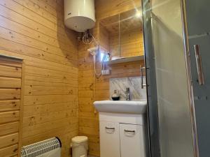 a bathroom with a white sink and a shower at Domki Letniskowe Martynka in Niechorze +42 photos