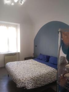 a bedroom with a bed with a blue and white bedspread at San Salvario No cooking between history and nightlife in Turin