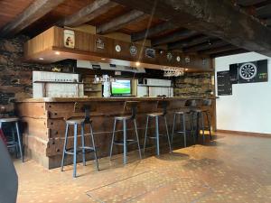 a bar with stools at a bar with a television at La Taverne Bretonne in Renac