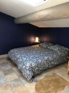 una camera da letto con un letto e una parete blu di La Suite a Mollégès