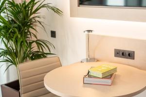 a table with books on it with a plant at INNSiDE by Meliá Tenerife Santa Cruz in Santa Cruz de Tenerife