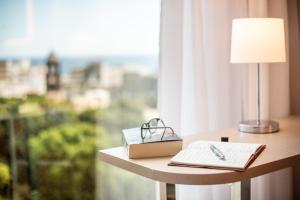 a table with a lamp and a book on a window at INNSiDE by Meliá Tenerife Santa Cruz in Santa Cruz de Tenerife