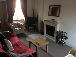 a living room with a couch and a fireplace at Burntisland Sands Hotel in Burntisland