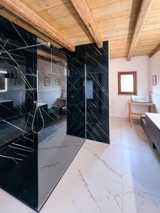 a bathroom with black marble walls and a wooden ceiling at Villa Hermes in Costermano +65 photos