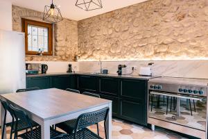 a kitchen with green cabinets and a wooden table at Villa Hermes in Costermano