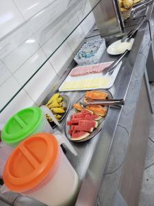 a buffet with plates of food on a counter at Hotel Divino Pai Eterno in Aparecida