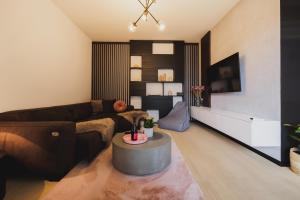 a living room with a couch and a table at ROSE LUXURY APARTMENT & 24h self check-in with private parking in Banská Bystrica