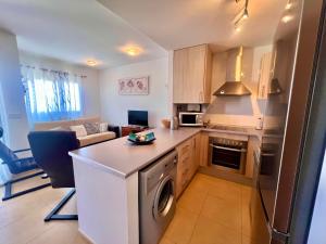 a kitchen and living room with a washer and dryer at Condado de Alhama JARDIN 13 SV62 in El Romero