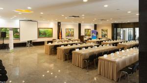 a conference room with tables and chairs and a screen at Hotel Sileks in Ohrid