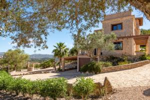 a house on a hill with a tree at Finca Estrella in Artá