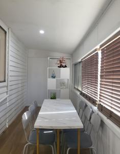 a dining room with a white table and chairs at Quite and friendly house in Noble Park