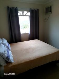 a bed in a bedroom with a window at Joinville Apartamento in Joinville +11 photos