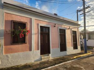 a small pink and white building with a window at Casa 1921 in Manati