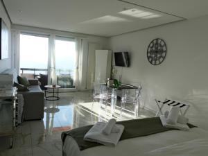 a white living room with a couch and a table at Panoramic Lugano in Aldesago