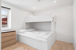a white room with a bed and a window at Spacious and Modern Fisherman's Cabin in Stamsund