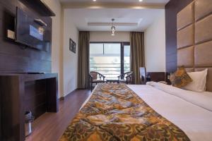 una camera d'albergo con un grande letto e una TV di The Bunkk Inn Hotel & Restaurant a Mussoorie