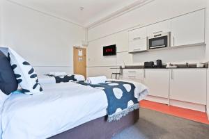 a bedroom with a large bed and a kitchen at Cosy hotel in Dudley in Dudley