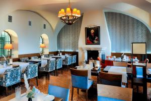 a restaurant with tables and chairs and a fireplace at Welcome Hotel Residenzschloss Bamberg in Bamberg +48 photos