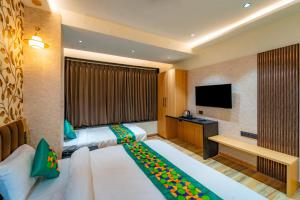 a hotel room with two beds and a flat screen tv at Treebo Neel Orchid in Ujjain +39 photos