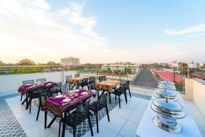 a patio with tables and chairs on a roof at Treebo Neel Orchid in Ujjain