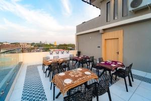 a patio with tables and chairs on a balcony at Treebo Neel Orchid in Ujjain