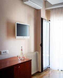 a room with a tv on the wall and a table at Hotel Sileks in Ohrid
