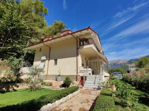 a small white house with stairs in a yard at Villa Vasil Mertiri in Himare