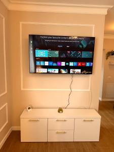 ein Flachbildfernseher, der an einer Wand hängt in der Unterkunft The Monarch Residential 6 in Lisaura + 28 Fotos