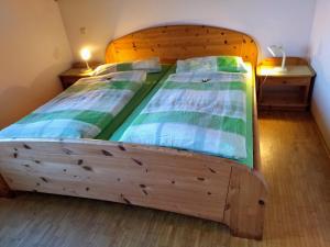 a wooden bed in a room with two twin beds at Ferienhof Alte Schmiede in Burgpreppach