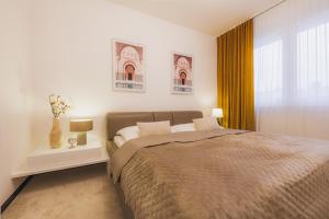 a bedroom with a large bed and a window at ROSE LUXURY APARTMENT & 24h self check-in with private parking in Banská Bystrica