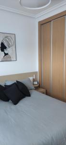 a bedroom with a white bed with a wooden door at Apartamento Giovanni - Marina D'Or in El Borseral +25 photos