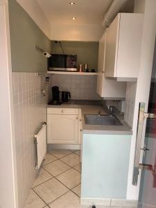 a small kitchen with white cabinets and a sink at Ruhe auf Borkum in Borkum +9 photos