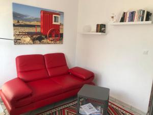 a red couch in a living room with a picture of a red fire truck at Ruhe auf Borkum in Borkum
