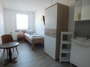 PruchtenにあるEinzelzimmer mit Gemeinschaftsbadのベッドと洗面台のある小さな部屋