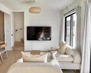 a living room with white furniture and a large window at 富士の宿燦々 in Fujiyoshida