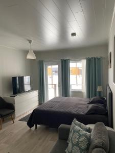 カラヨキにあるHiekkakuja Studios by Hiekka Bookingのベッド、テレビ、ソファのある寝室