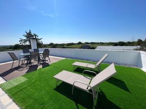 een patio met stoelen en tafels op een dak bij Masseria Parco delle Casette in Alberobello