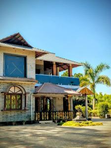 un edificio con una ventana grande y un porche en GaVi Stay's, en Sringeri