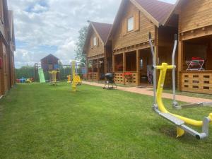 a yard with playground equipment in front of a house at Domki Letniskowe Martynka in Niechorze