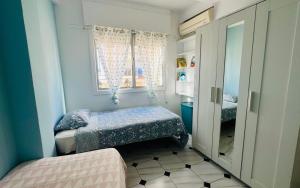 ein kleines Schlafzimmer mit zwei Betten und einem Fenster in der Unterkunft Castillo in Estepona