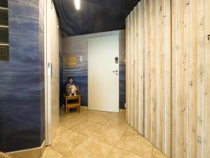 a hallway with a door and a person sitting at a table at Apartamento Triplex Boutique - 39JurereByTheSea in Florianópolis