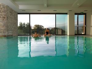 dos personas sentadas en una piscina en Borgotufi Albergo Diffuso, en Castel del Giudice