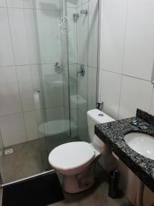 a bathroom with a toilet and a shower and a sink at Acomodações POSSUÃ in Contagem