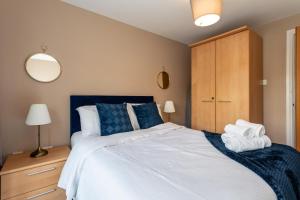 a bedroom with a large white bed with blue pillows at Slane Stay, Belfast in Belfast