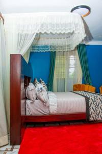a bedroom with a canopy bed with a red rug at Golden Ark Resort Hotel in Soroti