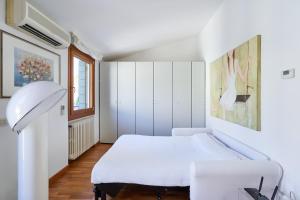 Casa Ambra la tranquillità in centro città في بادوفا: غرفة نوم بيضاء مع سرير أبيض ونافذة