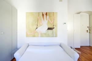 Casa Ambra la tranquillità in centro città في بادوفا: غرفة نوم بسرير ابيض ولوحة على الحائط