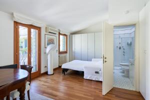 Casa Ambra la tranquillità in centro città في بادوفا: غرفة نوم بسرير أبيض وحمام