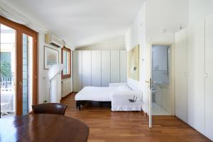 Casa Ambra la tranquillità in centro città في بادوفا: غرفة نوم بسرير ابيض وطاولة +30 صورة