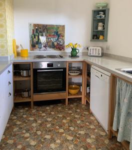 a kitchen with a counter with a stove and a dishwasher at 3 Linkside, Thurlestone, South Devon, family home close to the beach in Thurlestone +20 photos